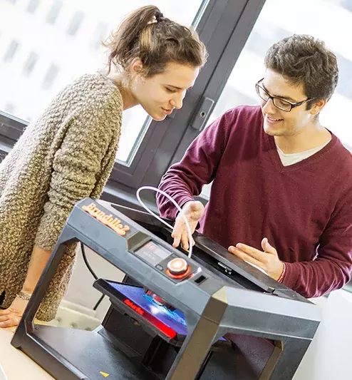 Deux jeunes utilisant une imprimante 3D