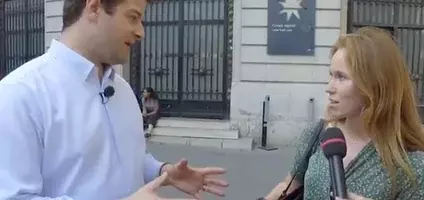 Un jeune homme s'adresse à une jeune femme rousse devant un micro